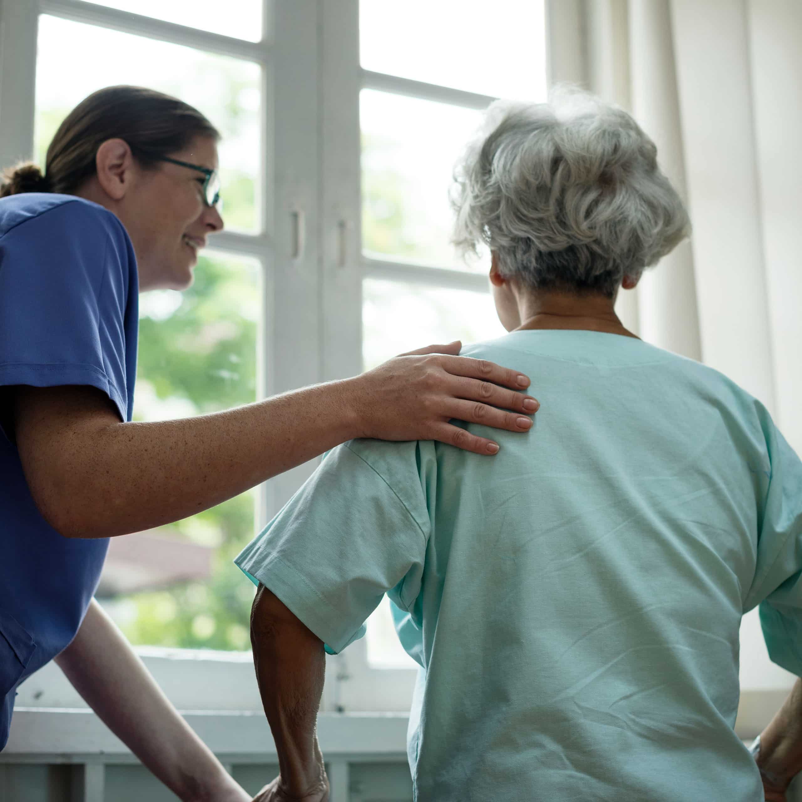 Caregiver offering a reassuring hand to senior by the window, emergency back up care