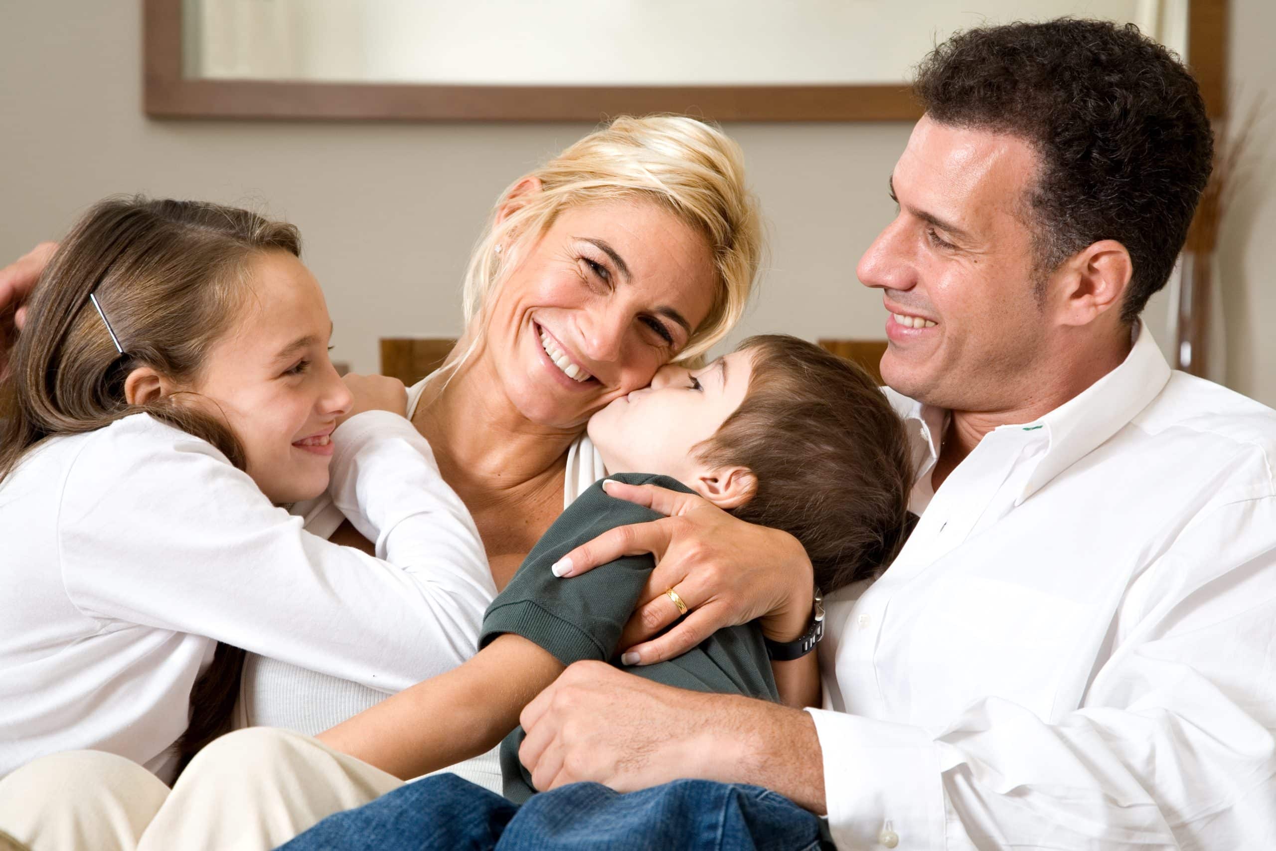 Family cuddled together on the couch, the peace of mind behind clear childcare rates and fees