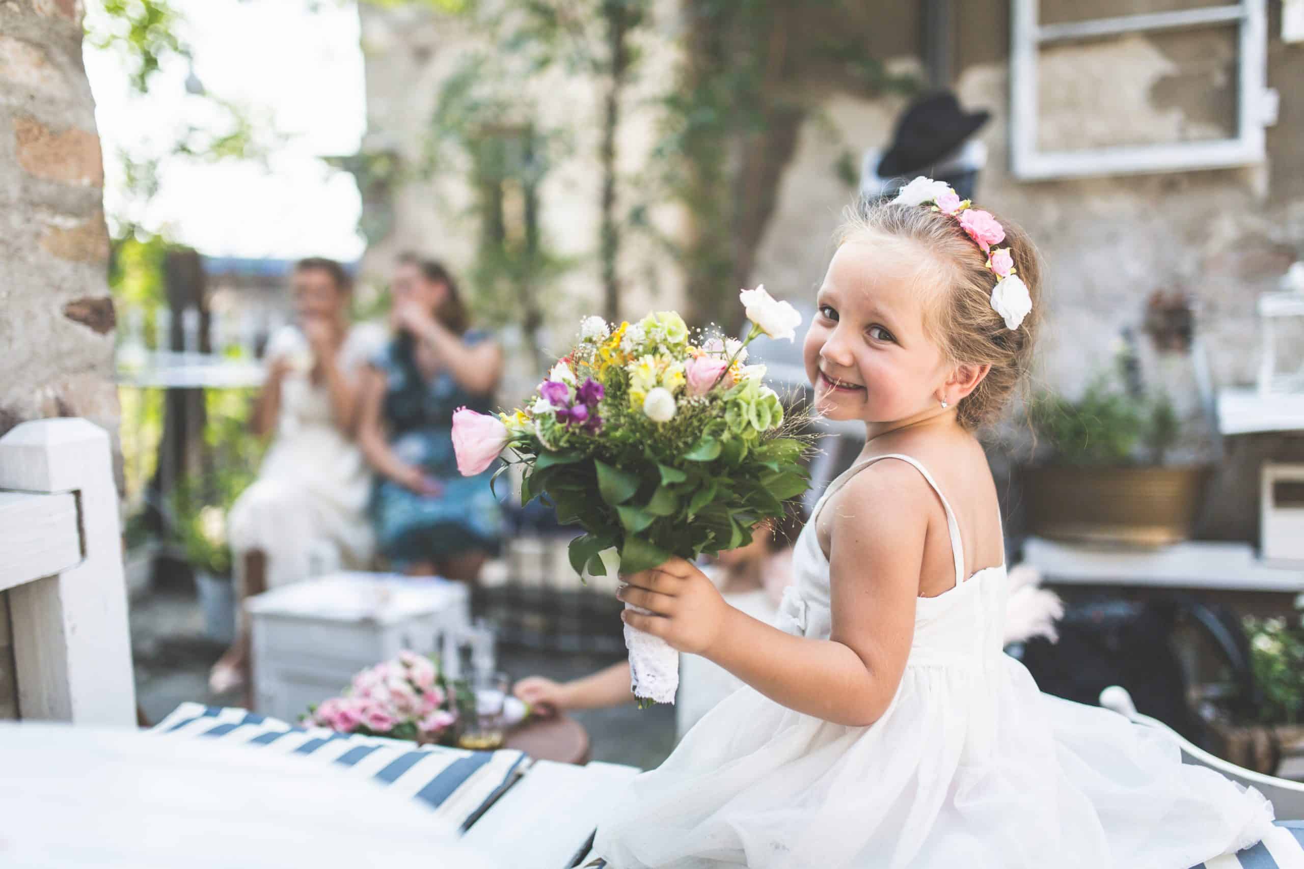 Flower girl smiling with a bouquet of flowers, part of the day's cherished moments