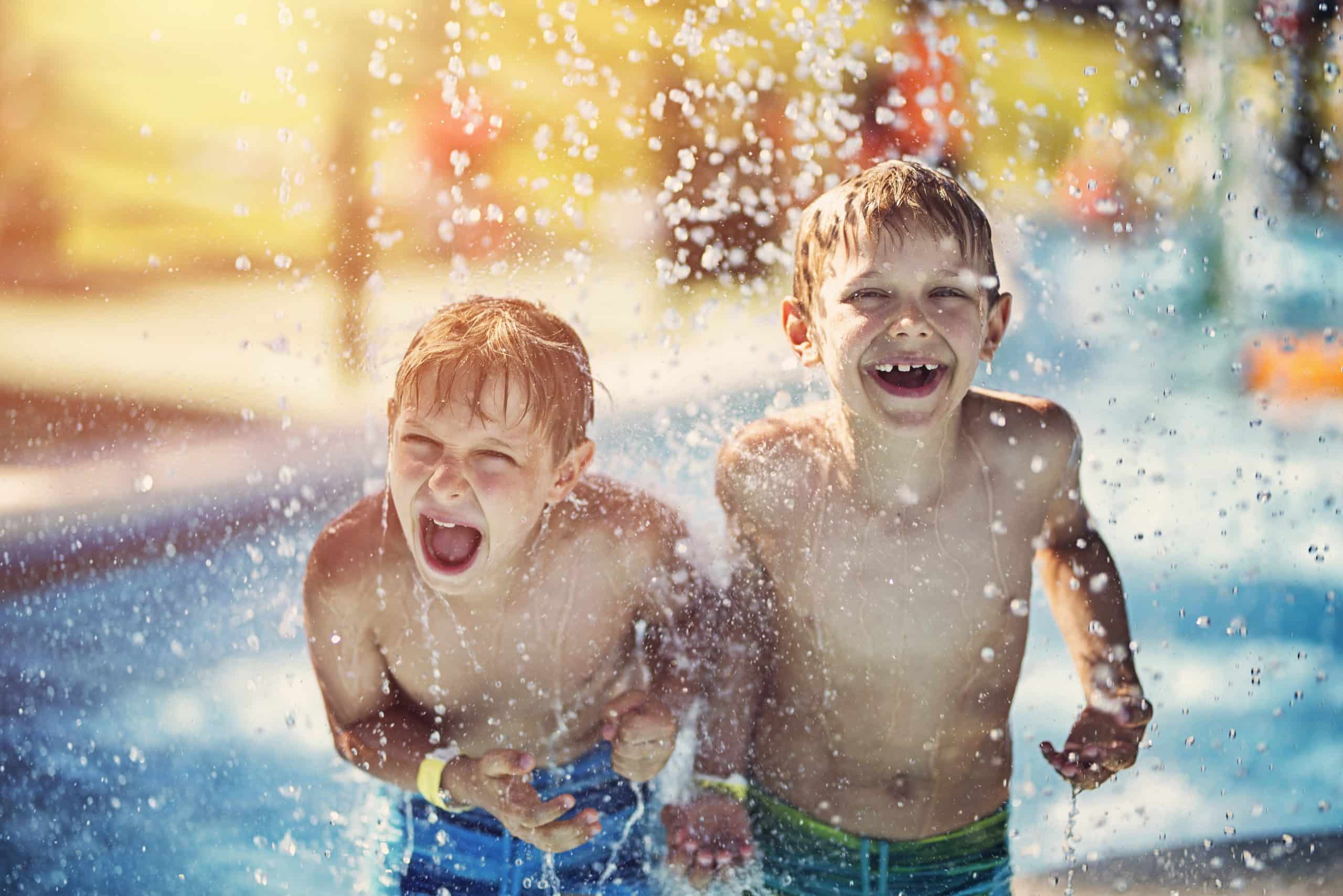 Kids laughing and splashing in a pool, care that makes family travel easier