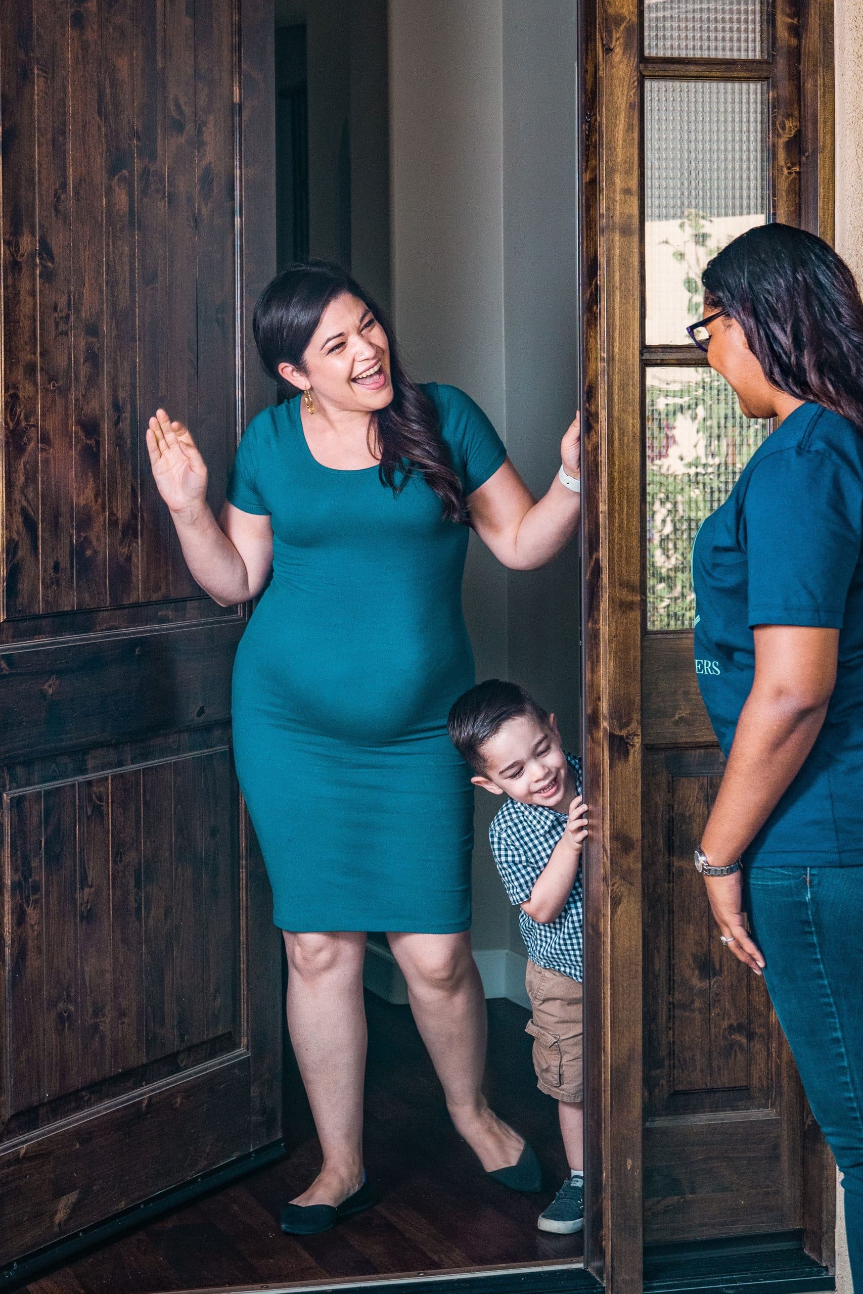 Mom and son greeting sitter at door for on demand flexible care