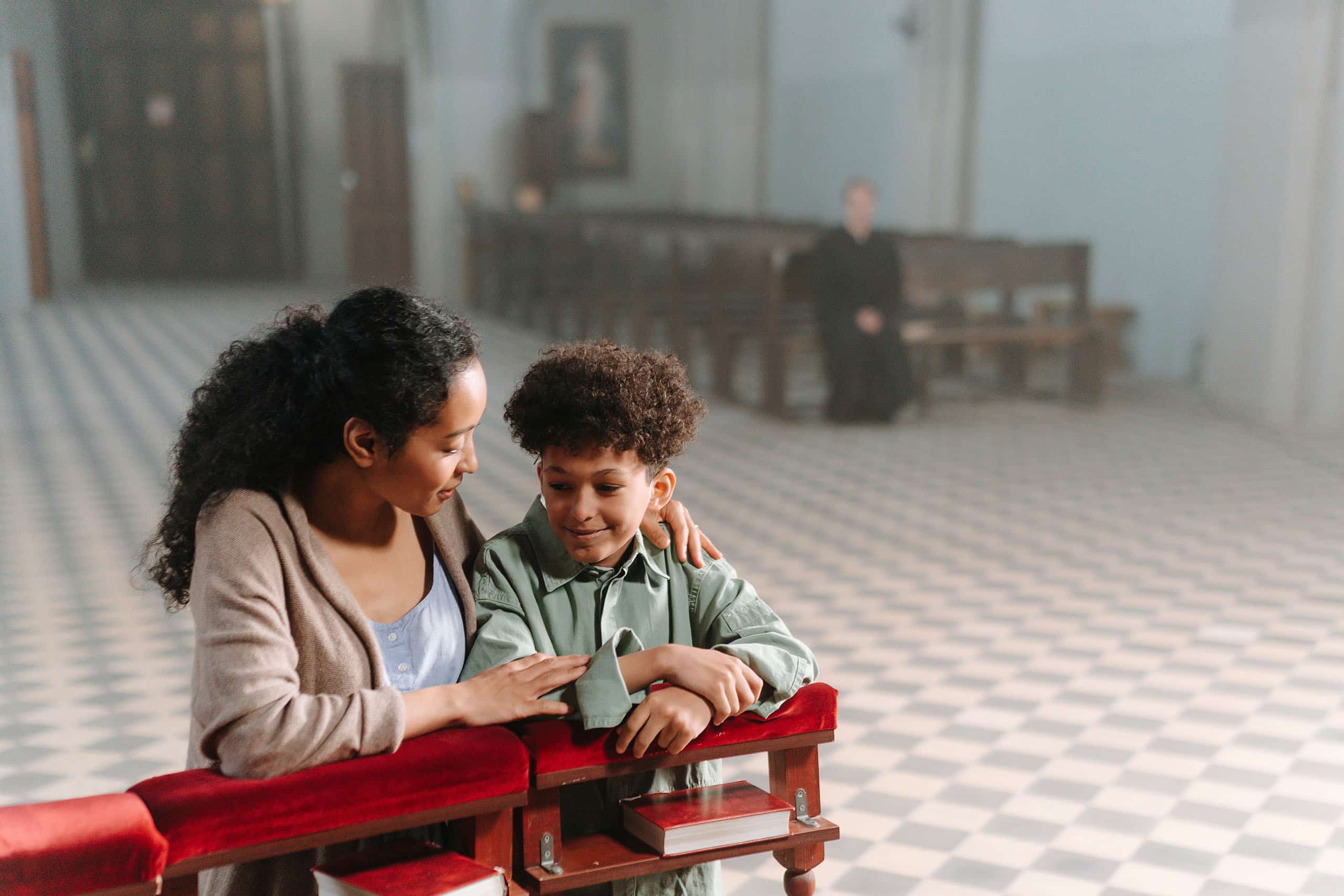 Mom and son sitting together in a church pew, trusted childcare for churches in Tucson