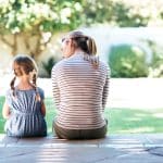 Mom and young daughter sitting together on a sunny porch, care available even without membership