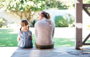 Mom and young daughter sitting together on a sunny porch, care available even without membership