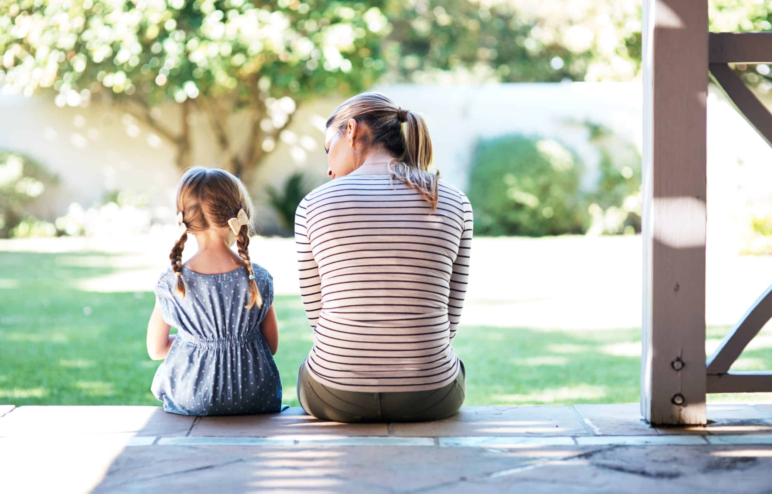 Mom and young daughter sitting together on a sunny porch, care available even without membership