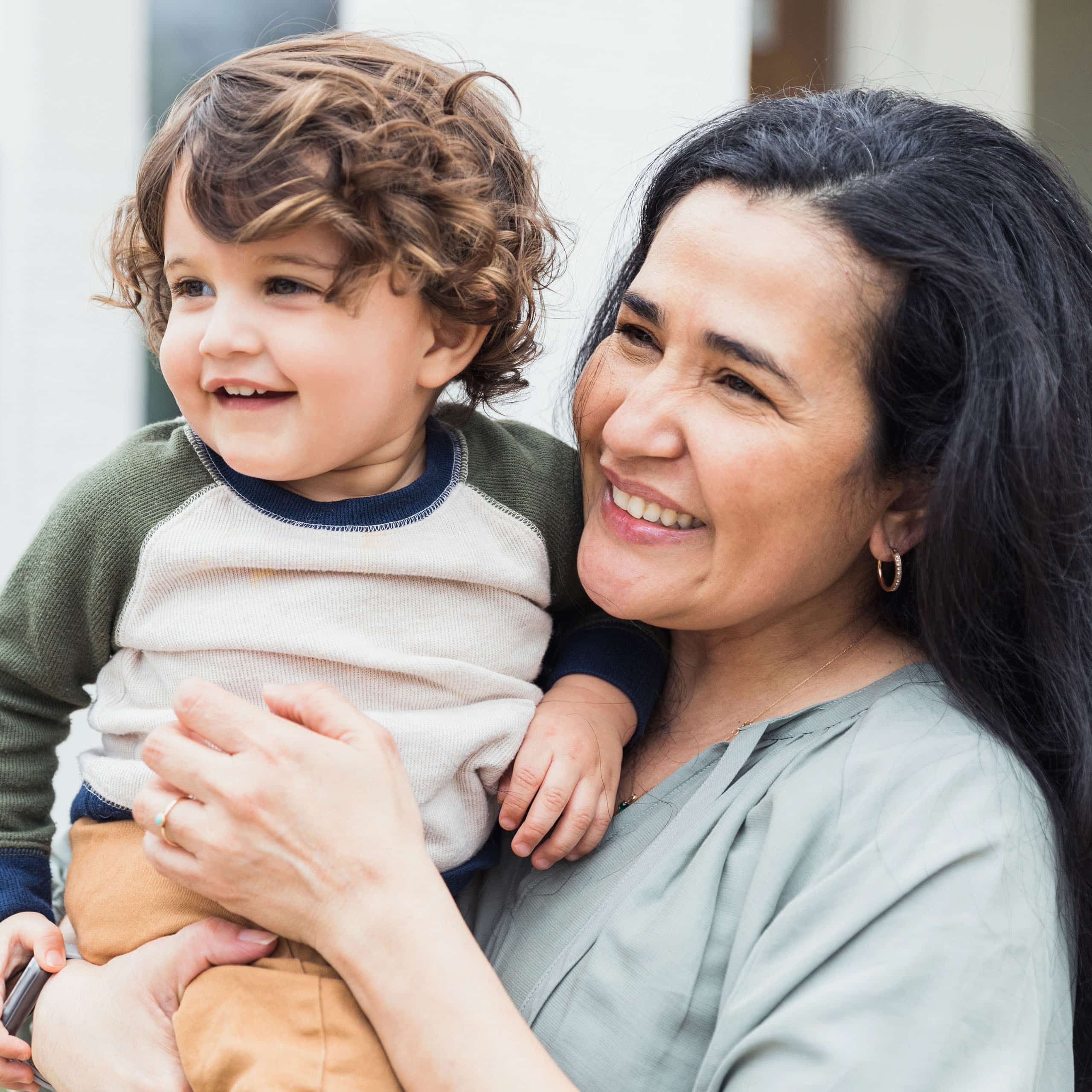 Nanny holding a smiling toddler close, the personal bond behind every placement