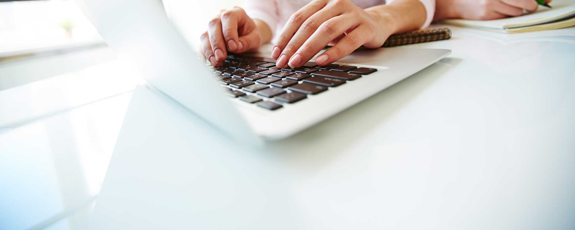 Close up of hands typing on a laptop keyboard, representing the Trusting Connections Client Information Update form